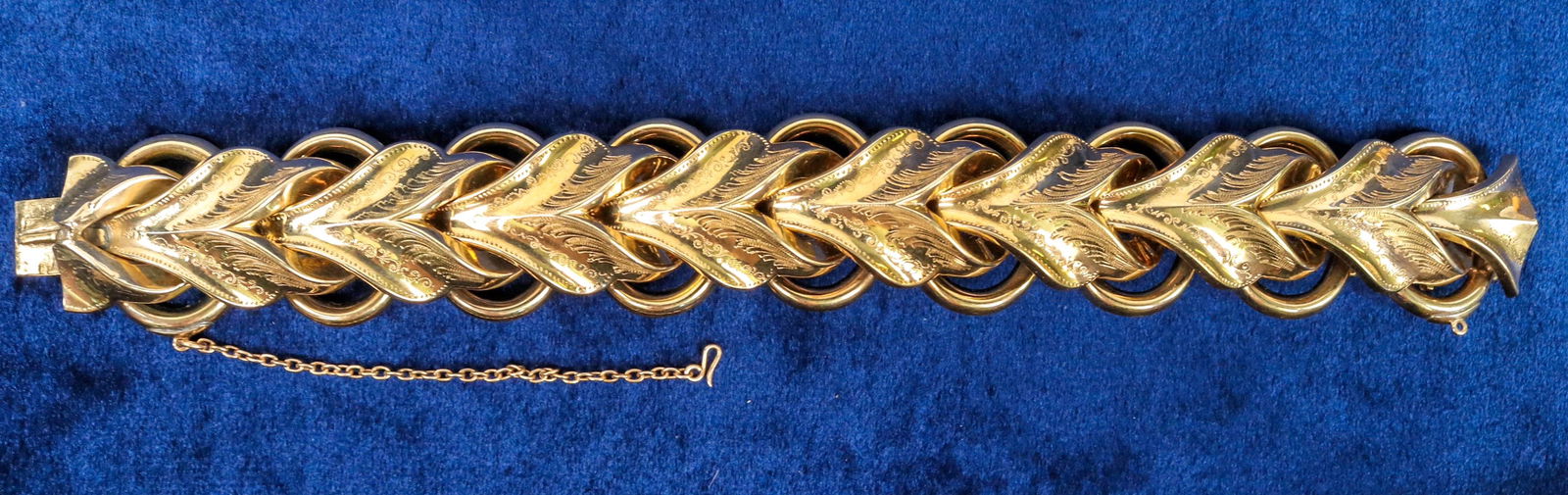 Gold Toned Bracelet [124983]: Vintage gold toned tink bracelet, etched design. 7", links approximately 1" wide. Excellent condition in original black leather case. ^Date: Country (if not USA): State: City: Provenance: