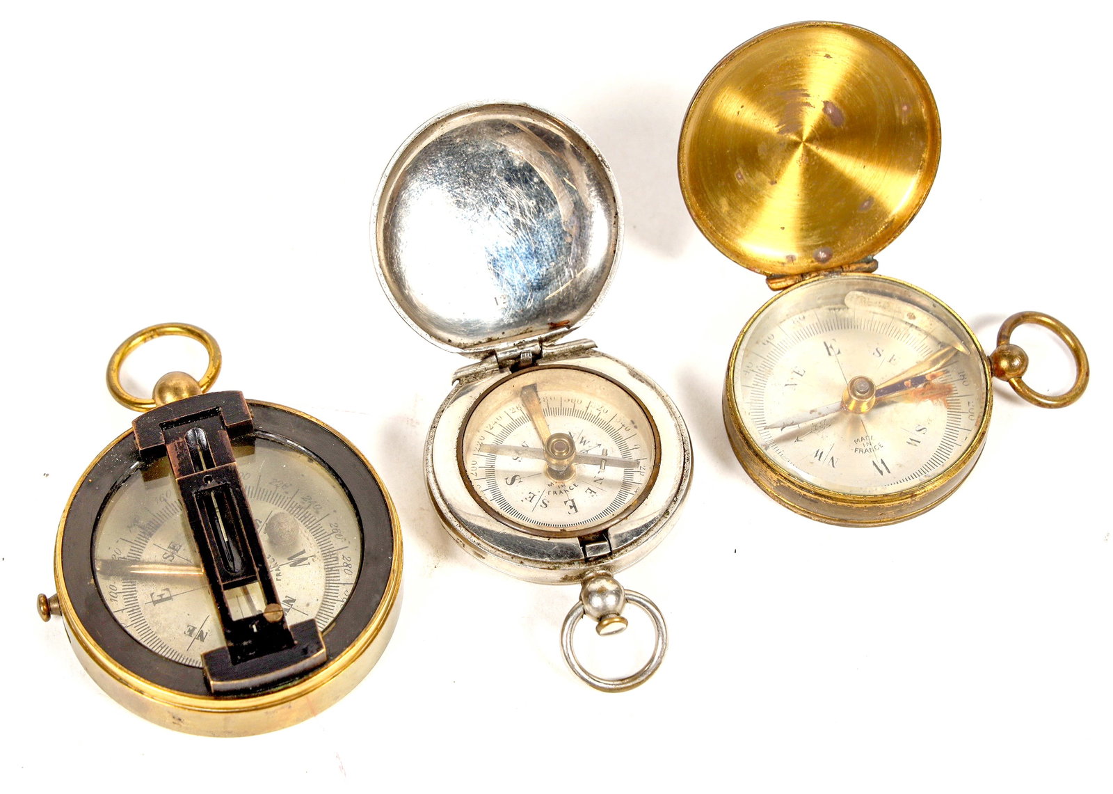 French made Pocket Compasses c.1920s (3) [202230]: This group of French made pocket compasses were made about 1920s. One with a removable cover and sighting lines. The other two have release covers. Fine craftsmanship however all three not in working