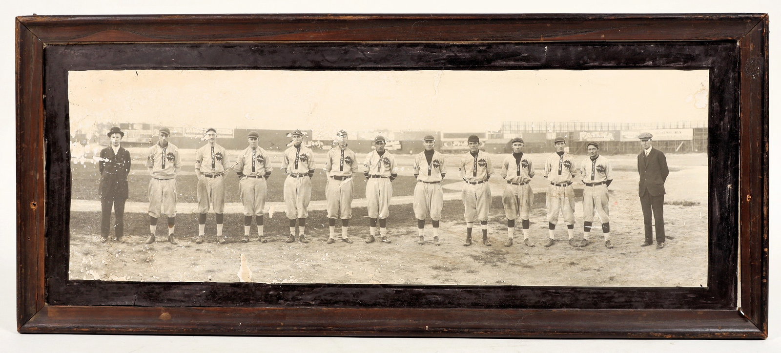 Denver "KC" Baseball Team Panorama Photo, c.1910 [200570]: A framed antique panoramic photo of a Denver baseball team, taken c. 1910. The players wear uniforms with the text "DENVER" and "KC". Photo depicts 11 players in uniform and 2 suited men. Rough condit
