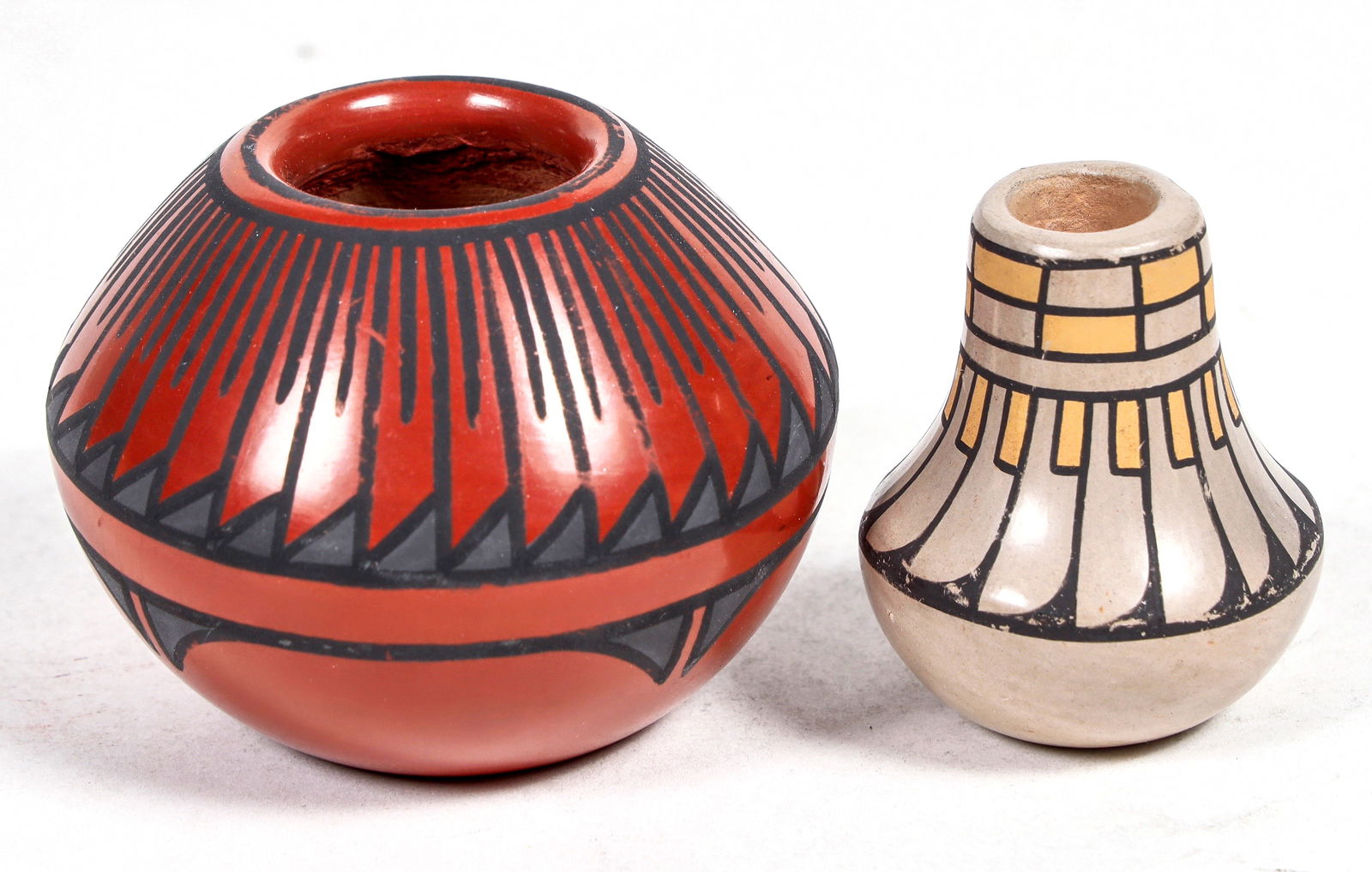 Two Miniature Pots [137319]: Black on Red, Santa Clara, artist Annette Vigil. 2" x 3". Miniature White clay jar, feather design, 1.75" x 1.5". Signed, but unreadable. Both in excellent condition^Date: Country (if not USA): State: