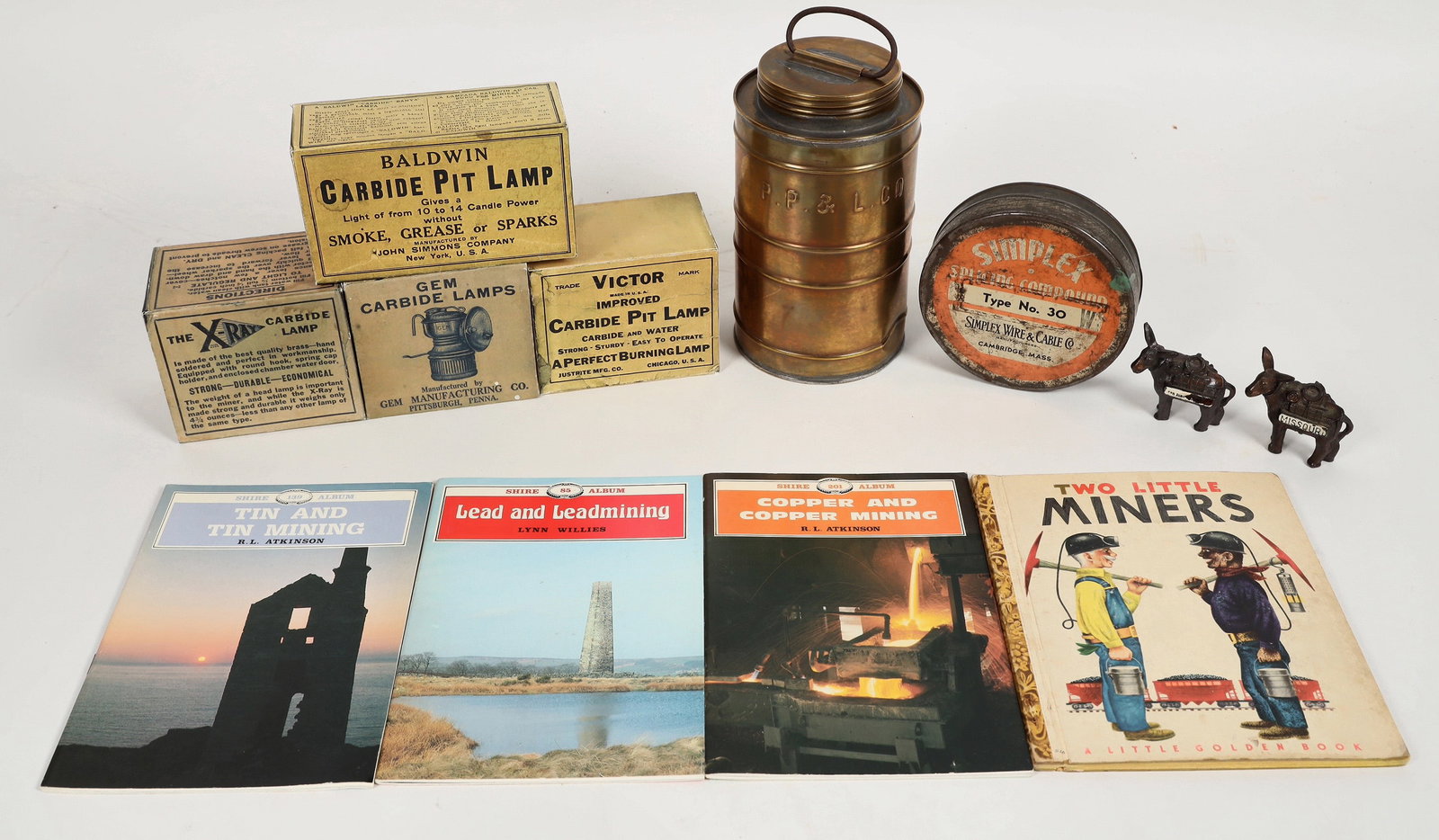 Mining Group [204250]: Mining group: reproduction carbide lamp advertisement boxes, children's literature, metal mining burro figurines ("Missouri" & "San Juan"), splicing compound tin, & golden tin with screw top and handl