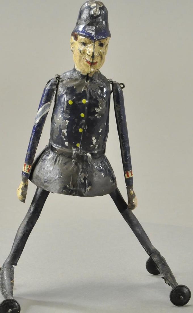 BOBBY COP ON WHEELS: Germany, hand painted tin bobby cop in full uniform, wind up appears at back, similiar action of arms moving up and down while legs move in and out simulating a skating action. 8 3/4" h.