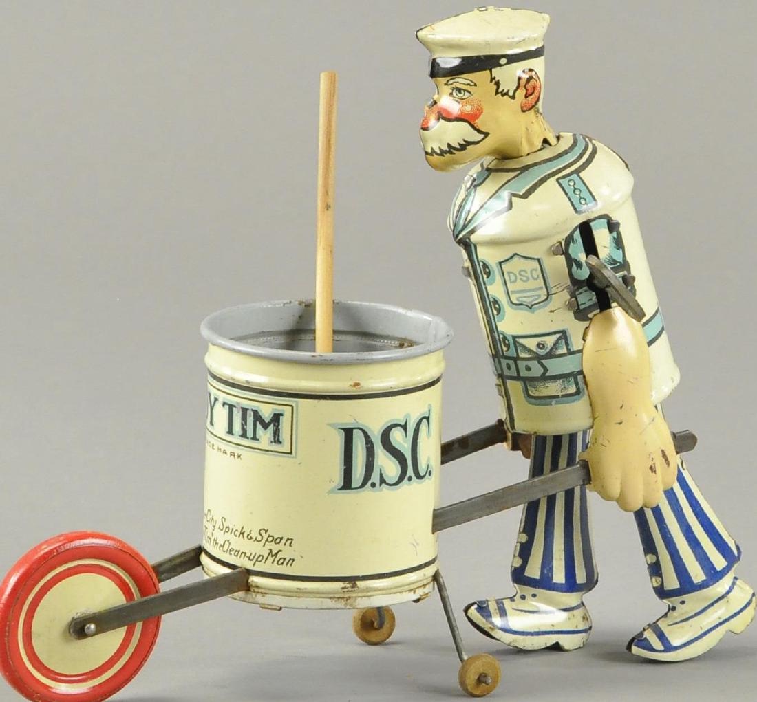 MARX TIDY TIM: Lithographed tin, depicts sanitation worker pushing trash barrel with broom, front reads 'Keep Your City Spick and Span Says Tidy Tim the Clean-Up Man,' key wind operated. 8.5" l.