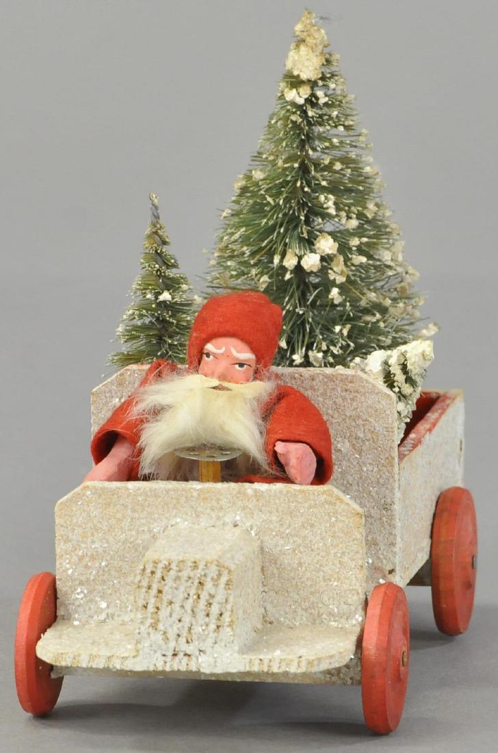 SANTA DRVING A TRUCK: 85. SANTA DRVING A TRUCK | (Exc. Cond.) | Crushed glass on wood truck w/Santa and bottle brush trees. | 8" l.