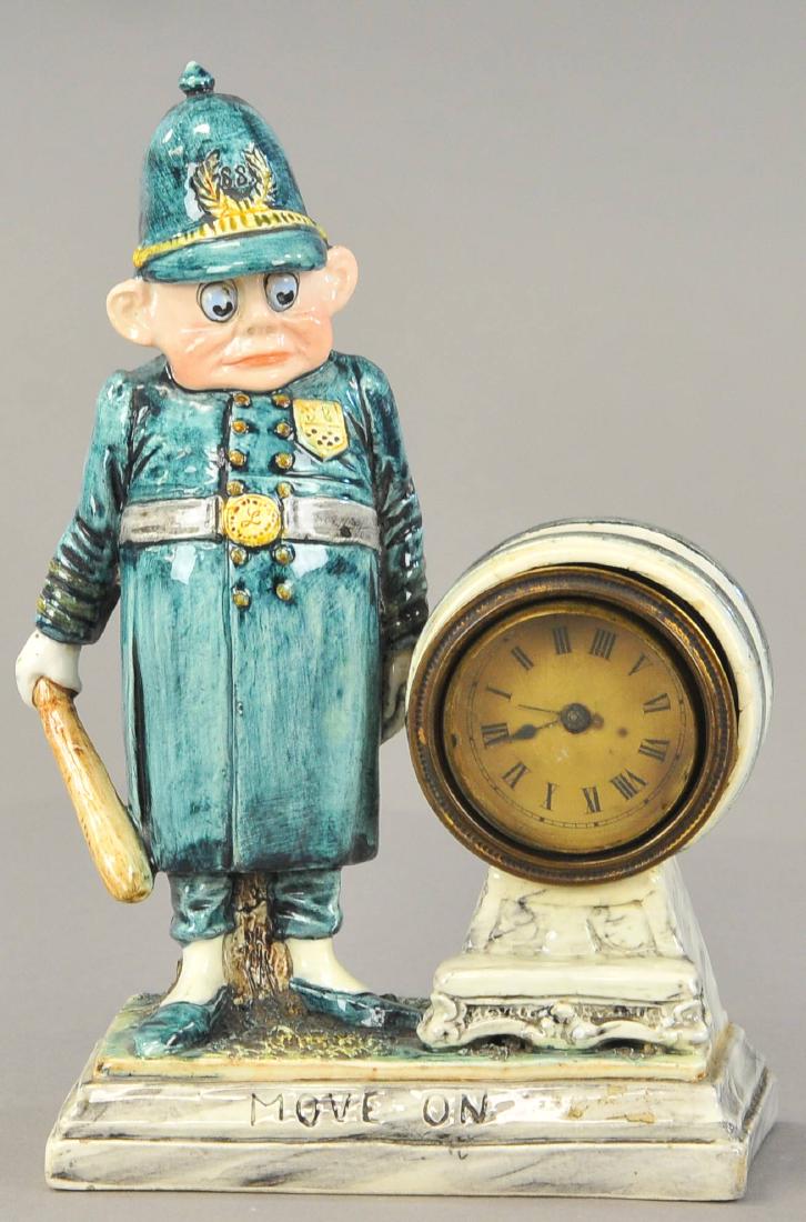 MAJOLICA PALMER COX BOBBY CLOCK: 120. MAJOLICA PALMER COX BOBBY CLOCK | This English Brownie Policeman is mounted on a clock platform with "Move On" inscribed on it. 8.5" h.