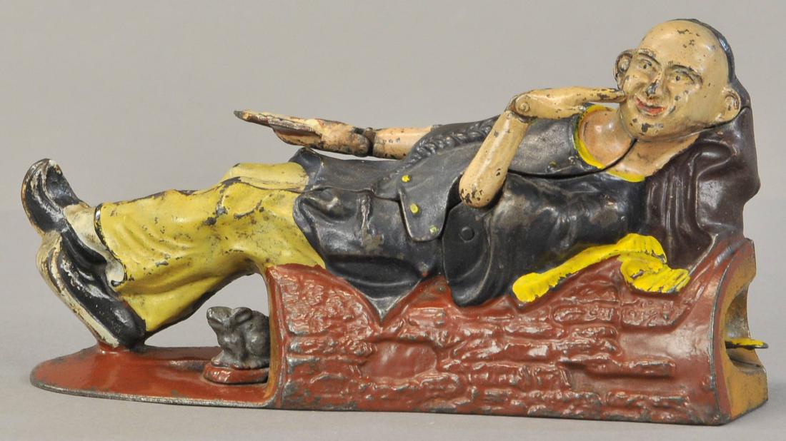 RECLINING CHINAMAN MECHANICAL BANK: 479. RECLINING CHINAMAN MECHANICAL BANK | Circa 1882, J. & E. Stevens co., Cromwell, CT.