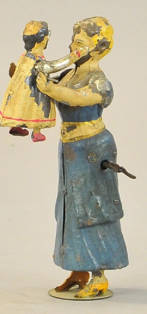 GUNTHERMANN MOTHER LIFTING CHILD: 1064. GUNTHERMANN MOTHER LIFTING CHILD | Very endearing early German tin toy simulates a mother lifting the child into the air, hand painted. 7" h.