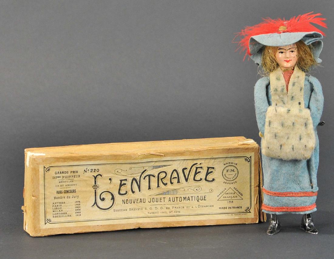 BOXED MARTIN PARISIAN WOMAN W/ MUFF: 17. BOXED MARTIN PARISIAN WOMAN W/ MUFF | c. 1910 "LEntravee", well dressed figure, wears blue felt long skirt with accent shawl and muff, a beautiful toy with mechanical action, she walks taking very