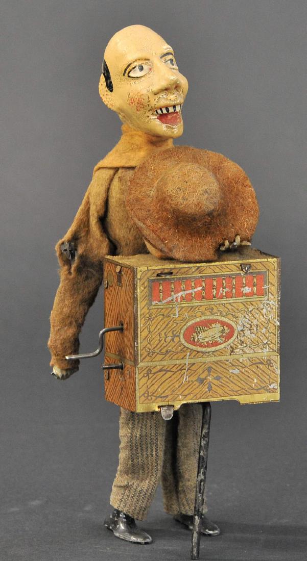 GROTESQUE ORGAN GRINDER: 78. GROTESQUE ORGAN GRINDER | France, S.I.J.I.M, hand painted composition head, lithographed tin organ, wears cloth outfit, quite whimsical, clockwork driven. | 9" h.