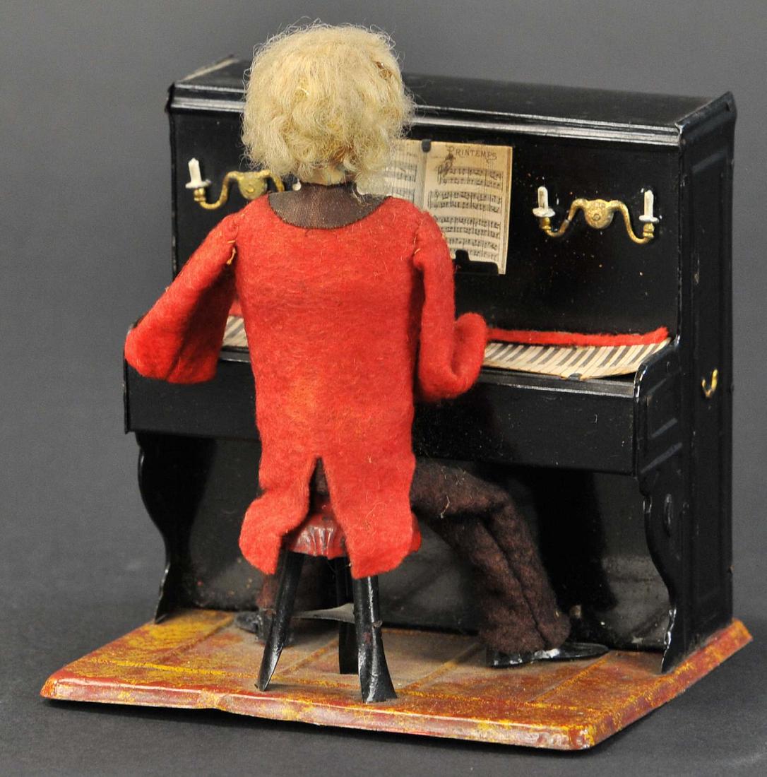 MARTIN PIANIST: 123. MARTIN PIANIST | c. 1902 "Le Petit Pianiste ". Early toy depiction of seated man at the piano, wears felt suit, has full head of hair, clockwork driven, he moves his hands across the keys of the 