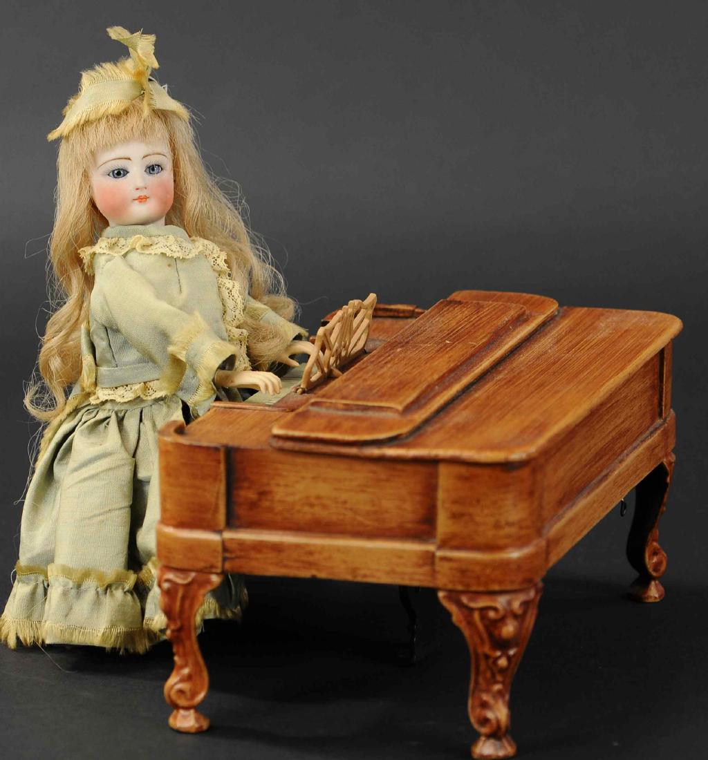 MECHANICAL PIANO PLAYER: 198. MECHANICAL PIANO PLAYER | Circa 1885, early American clock work toy created by Secor and Ives, period dressed woman with painted bisque head, plays the piano while turning her head from side-to-s