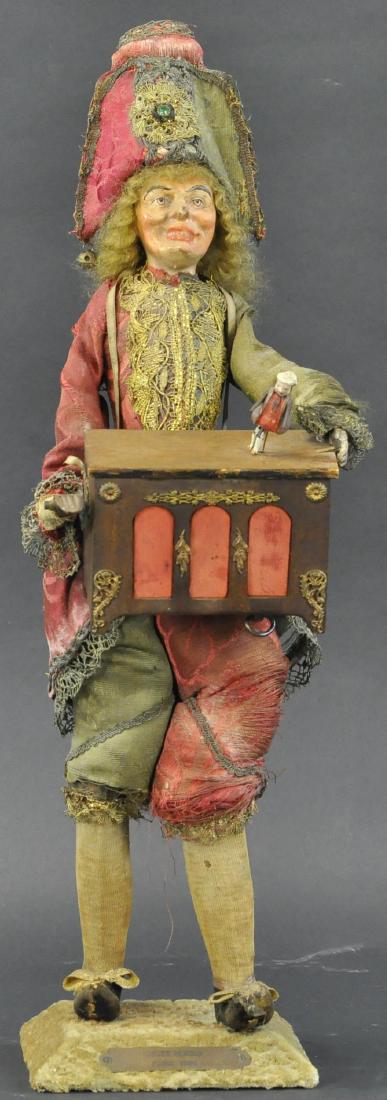 FRENCH "POLICHINELLE" ORGAN GRINDER WITH DANCING: 250. FRENCH "POLICHINELLE" ORGAN GRINDER WITH DANCING | DOLL Standing "Polichinelle" figure with paper mache head, wearing original clothing [somewhat frail and dusty], he holds a wood box simulating 