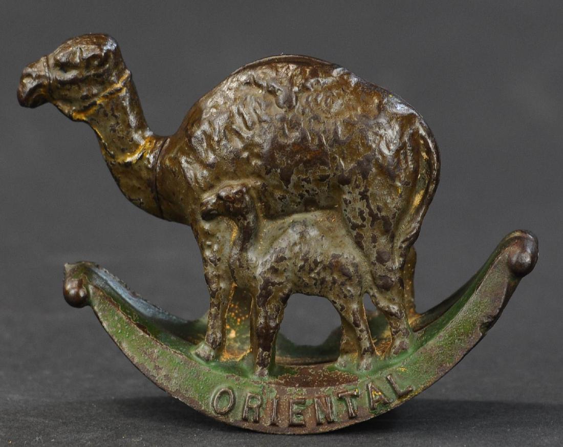 ORIENTAL CAMEL STILL BANK: 306. ORIENTAL CAMEL STILL BANK | US, cast iron, scarce bank, painted, rocking base embossed "Oriental". | 5.5" l.
