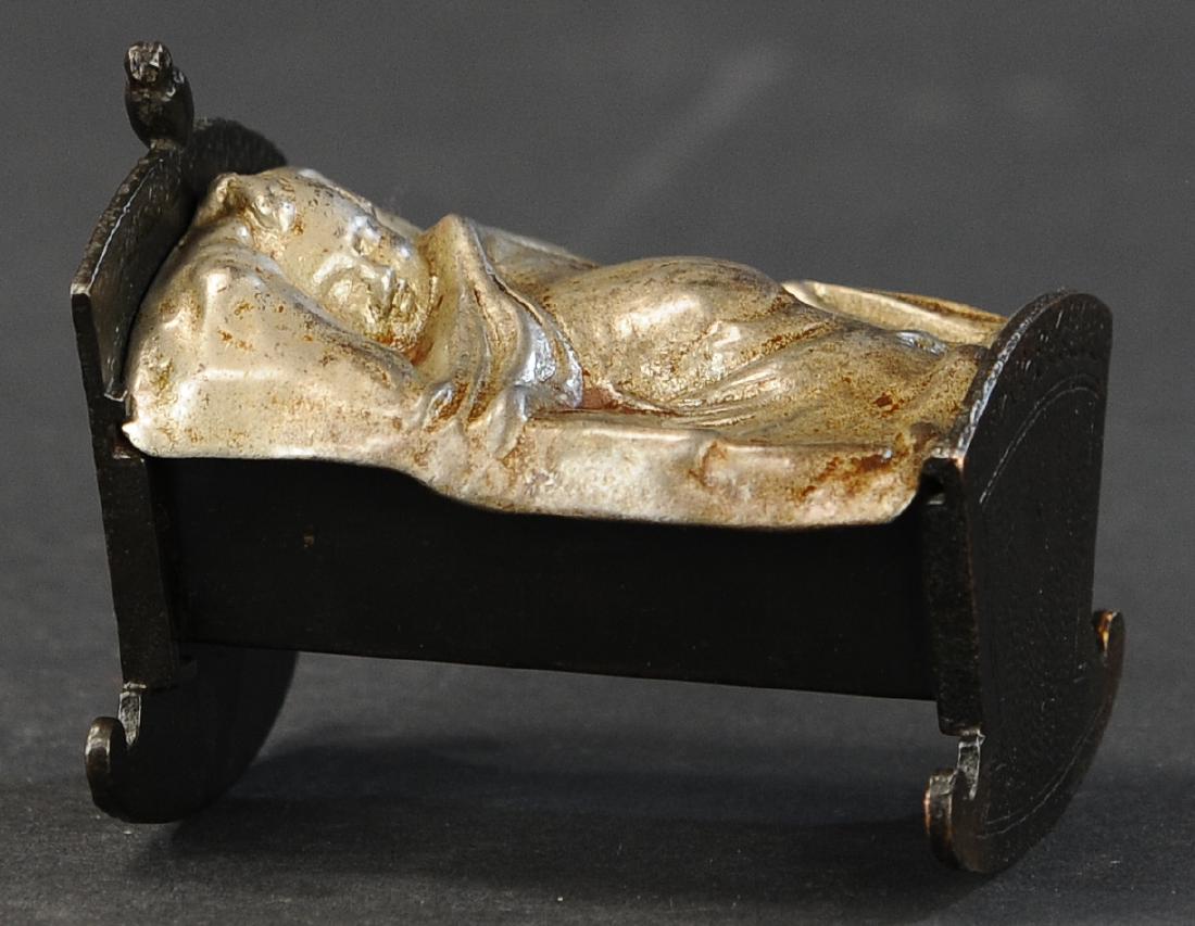 BABY IN CRADLE STILL BANK: 340. BABY IN CRADLE STILL BANK | Grey Iron Casting Co., c. 1890s. | 4" l.