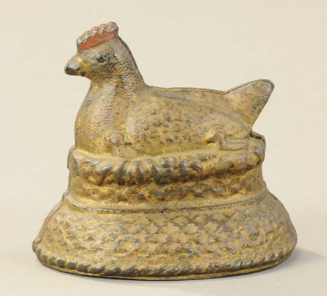 HEN ON NEST STILL BANK: 148. HEN ON NEST STILL BANK | c. 1900's, cast iron, rare, slot on base version. | 3.5" h. | (Exc. Cond.) | $600 - $800