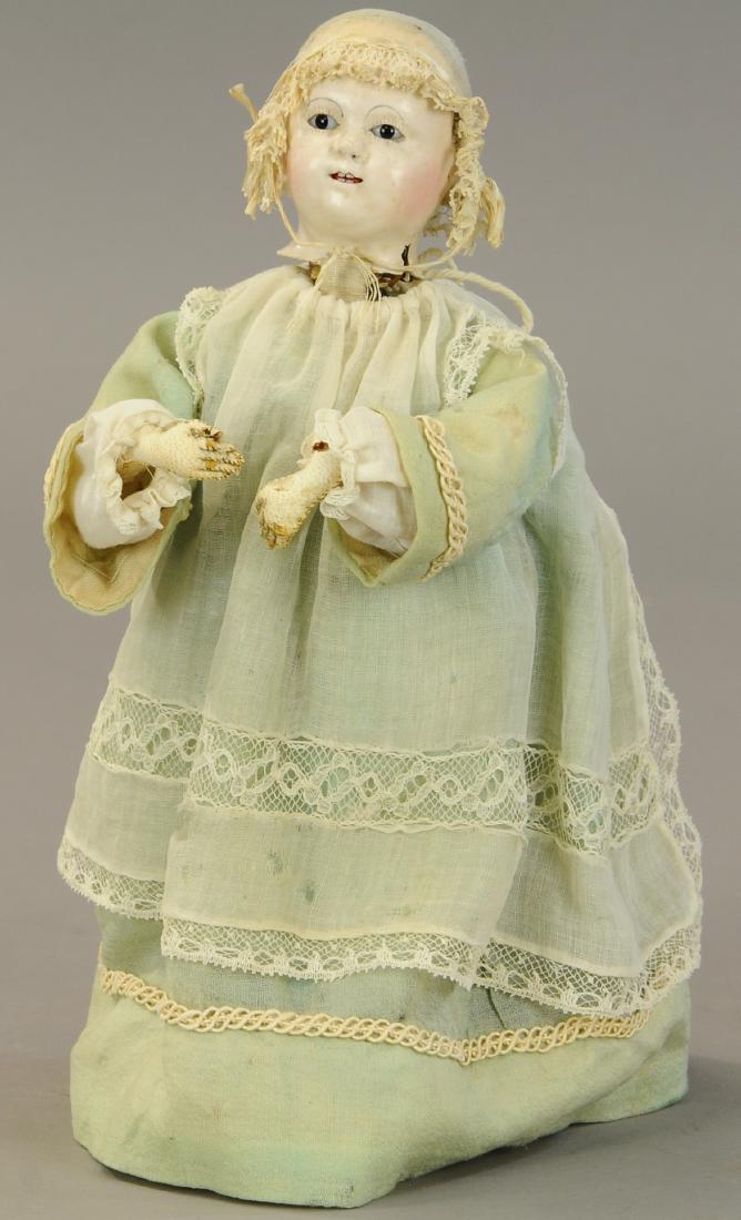 FRENCH PAPIER MACHE HEAD CHILD MECHANICAL TOY: 476. FRENCH PAPIER MACHE HEAD CHILD MECHANICAL TOY | Lovely French Mache head with tiny bamboo teeth wearing original bonnet, gauze and lace dress and mounted to a green metal platform [with metal pla