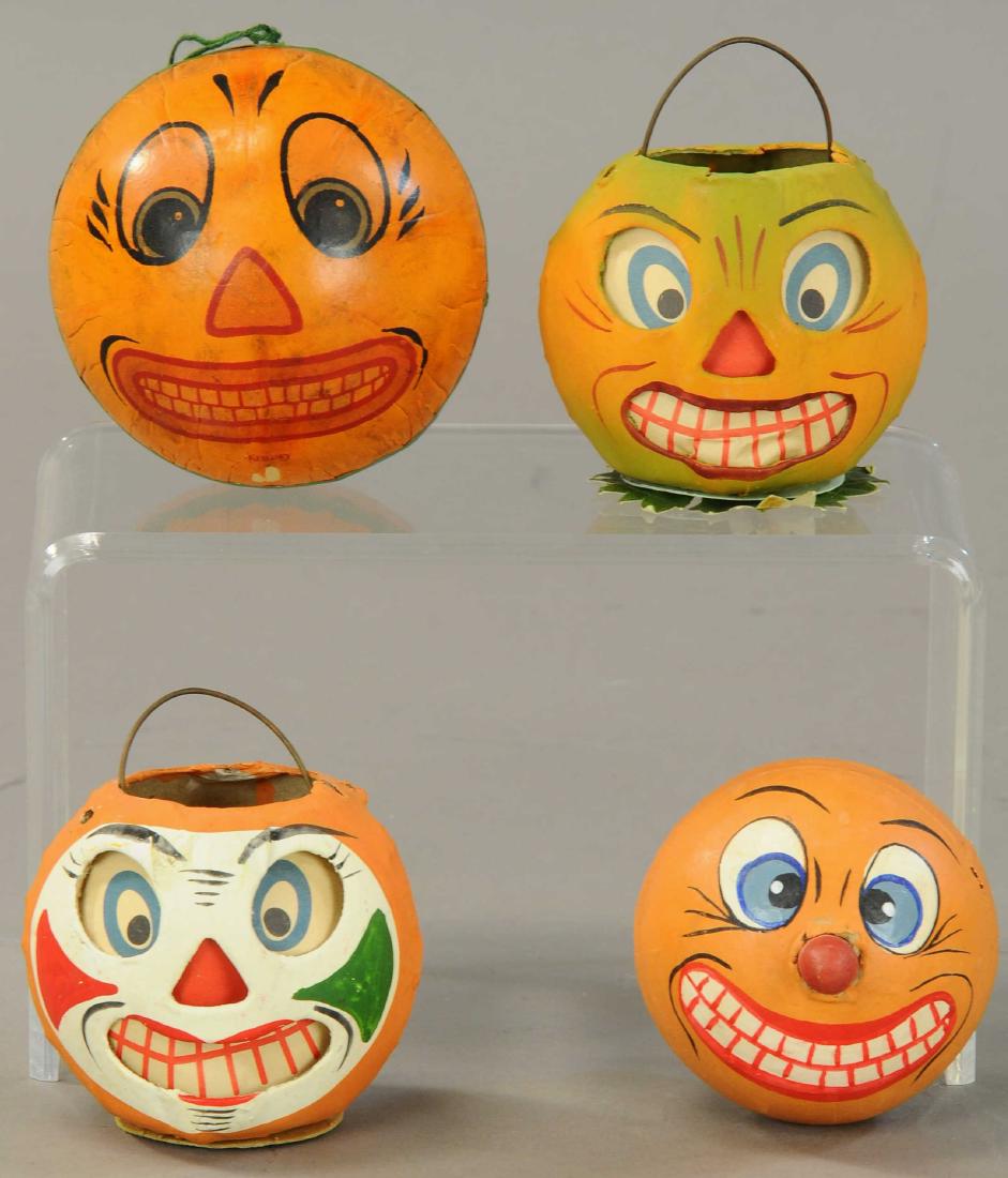 FOUR WONDERFUL JACK-O-LANTERNS: 548. FOUR WONDERFUL JACK-O-LANTERNS | Two paper face inserts, two face rattle and male-female two face pumpkin figure, all of German pressed composition. | 3"-3 1/2". | (Very Good to Excellent Conditi