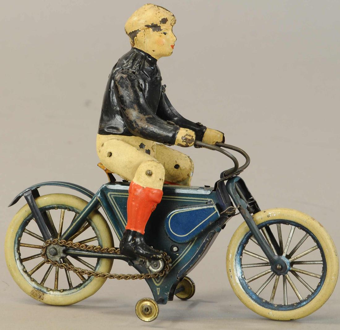 GUNTHERMANN BOY PEDAL CYCLE: 1145. GUNTHERMANN BOY PEDAL CYCLE | Germany, c. 1910, hand painted tin figure on lithographed tin cycle, activated clockwork causes legs to seemingly pedal in place. | 8 "l. | Seldom found all origina