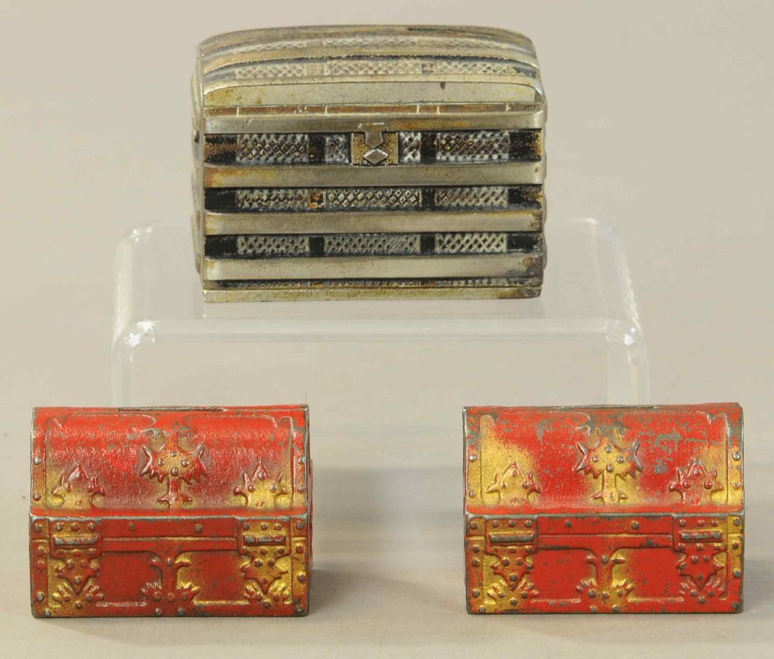 THREE CHEST STILL BANKS: 1137. THREE CHEST STILL BANKS | Lot includes two treasure chests and a nickeled trunk bank. | 2" - 2.5" h. | All Original Condition. | $125 - $250