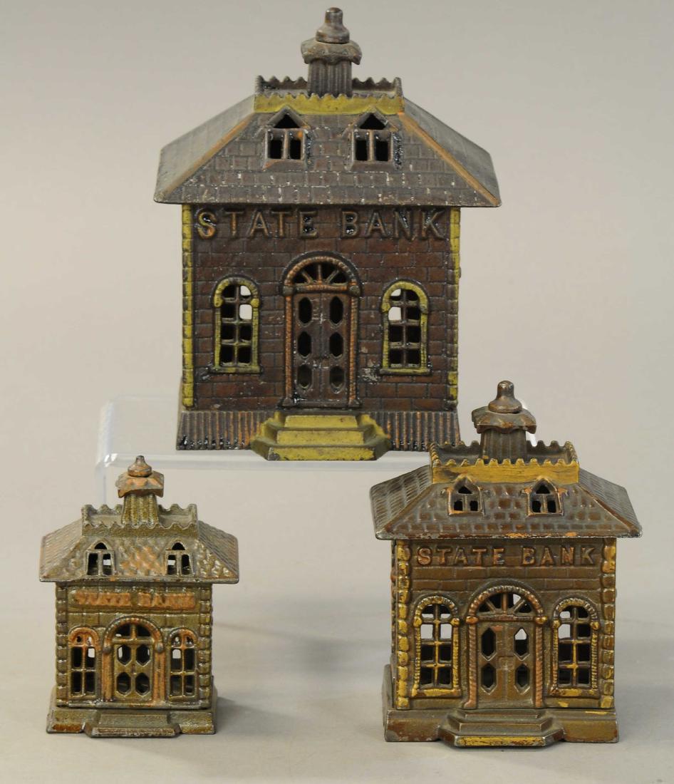 THREE KENTON BUILDING STILL BANKS: 1230. THREE KENTON BUILDING STILL BANKS | Lot includes; large state bank w/ fixed door, medium state bank w/ fixed door, and a small state bank. | 4.25" - 7" h. | All Original Condition. | $125 - $250