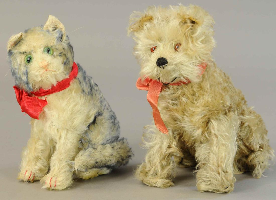 EARLY STEIFF DOG AND CAT: 1322. EARLY STEIFF DOG AND CAT | Cat has green glass eyes and block letter button with beautiful blue tipped fur; dog has long plush hair and brown glass eyes. | Both 8" | Both (Near Mint Cond.) | $20