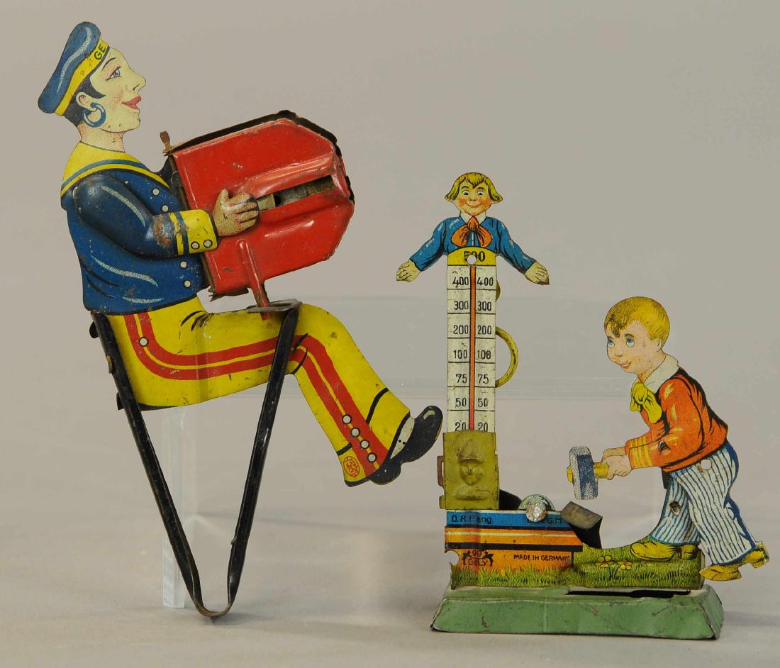 TWO GELY GERMAN HAND ACTIVATED TOYS: 71. TWO GELY GERMAN HAND ACTIVATED TOYS | Carnival toy is missing spring bar button, other has working bellows though has some minor tears to paper. | 6.5" h. | As noted, lithography in All Original C
