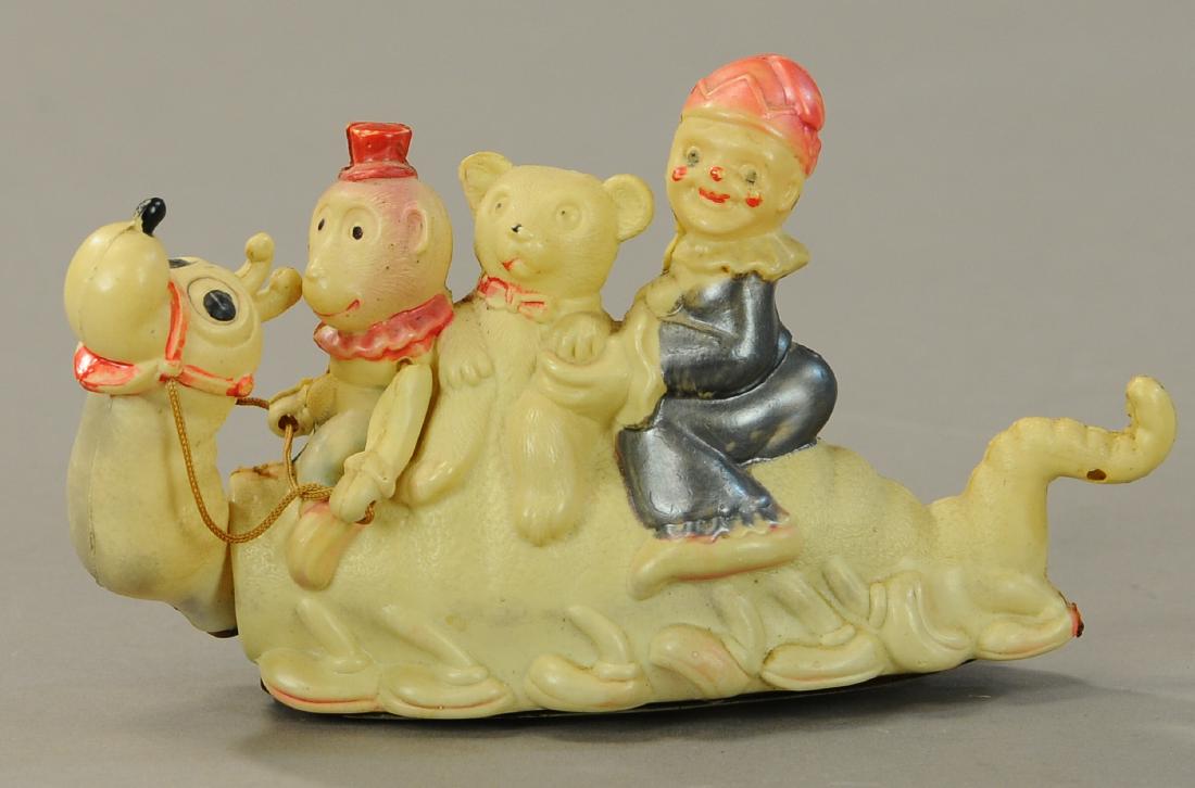 CHILDREN RIDING MECHANICAL CENTIPEDE: 87. CHILDREN RIDING MECHANICAL CENTIPEDE | Wind-up celluloid toy. | 7" l. | All Original Condition. | $150 - $300