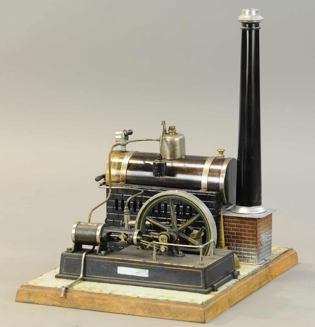 JF JON FALK LARGE HORIZONTAL STEAM PLANT: 413. JF JON FALK LARGE HORIZONTAL STEAM PLANT | circa 1908, wooden base, large flywheel, pressure gauge, burnished boiler, funnel, water bucket & oil container, with water pump & box. | Base 15" x 11"