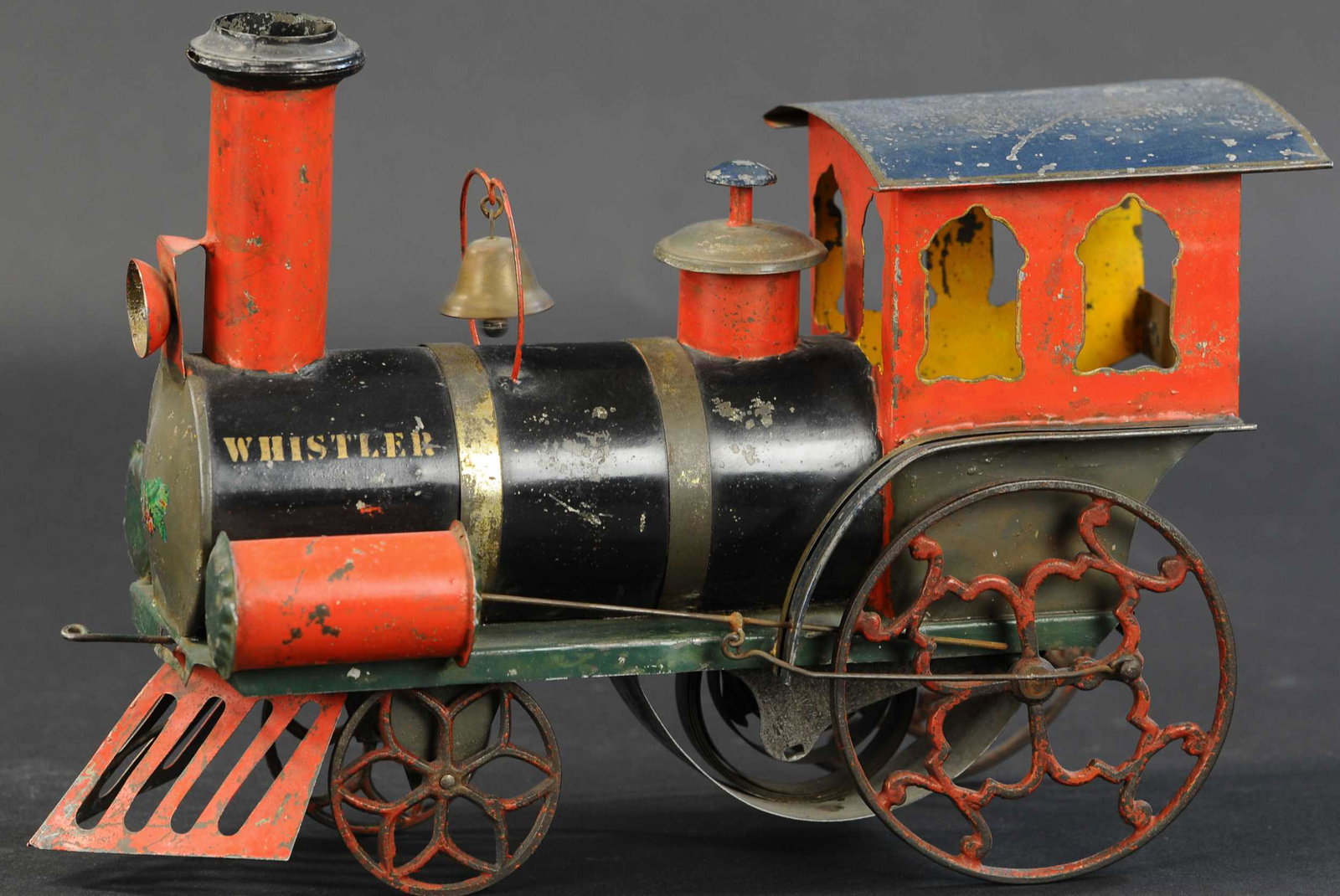 IVES WHISTLER CLOCKWORK LOCOMOTIVE: 328. IVES WHISTLER CLOCKWORK LOCOMOTIVE | circa 1875, brilliantly designed early tin engine is clockwork driven and actually emits a whistling sound from the stack on the boiler as it chugs across the