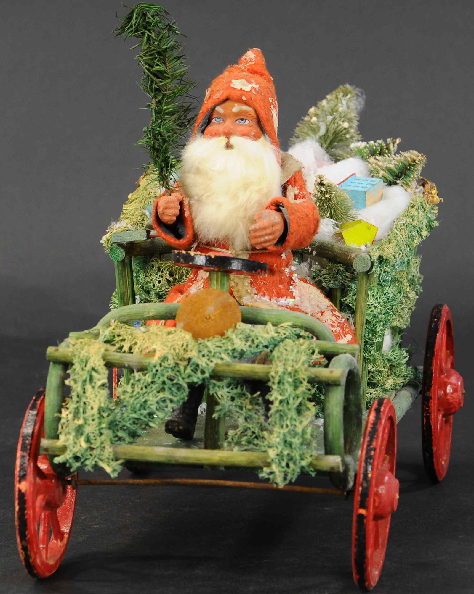 SANTA DRIVING AN EARLY AUTO: 447. SANTA DRIVING AN EARLY AUTO | Loaded with Christmas toys, this loofah decorated vehicle has a red robe Santa at the wheel, sporting a rabbit fur beard and holding a feather tree, a hard one to fi