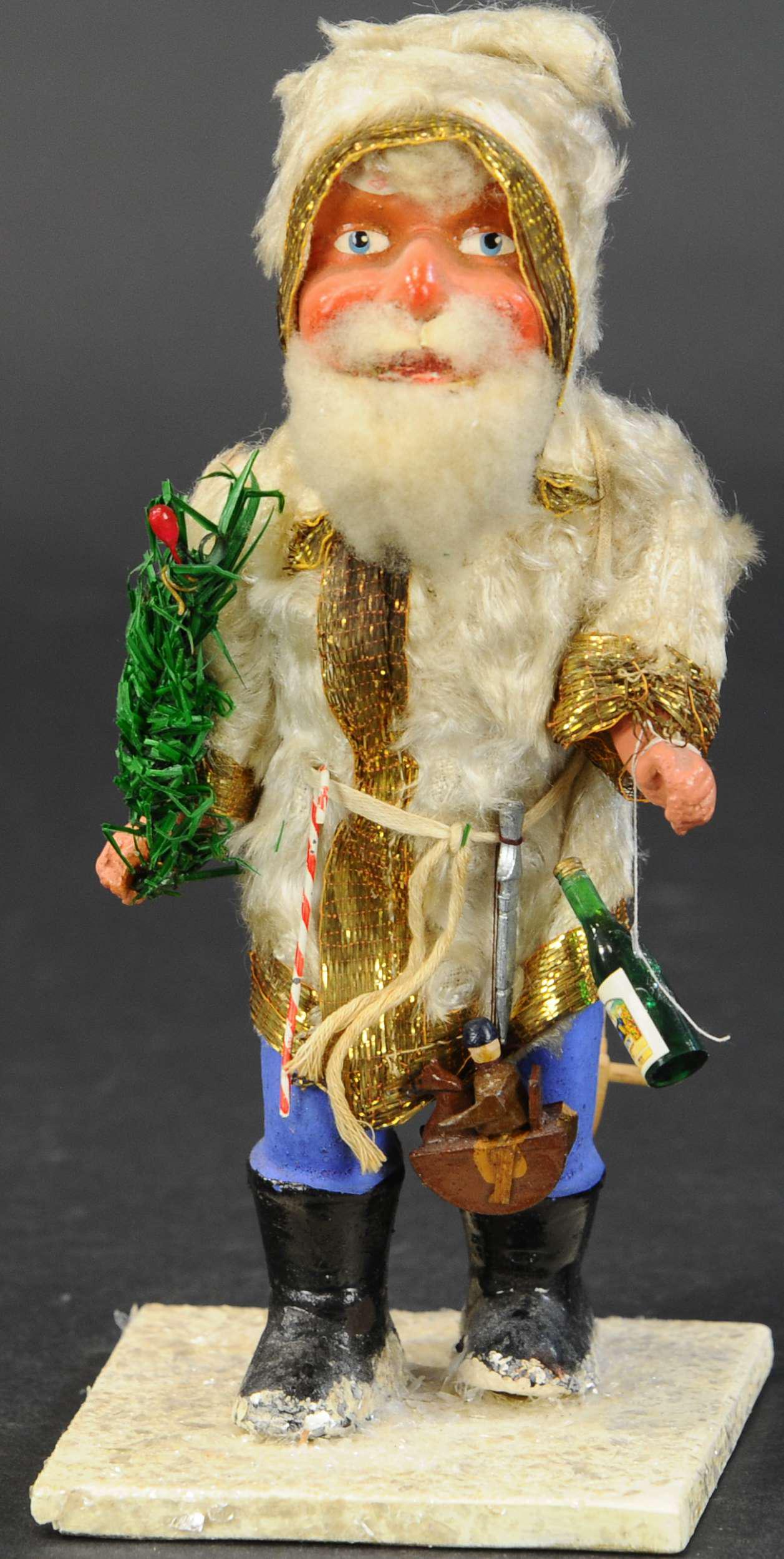 POLAR BEAR ROBED SANTA: 455. POLAR BEAR ROBED SANTA | Post war German figure, composition Santa Claus wearing magnificent white fur robe trimmed in gold strands and carrying many Christmas gifts. | 8" height. | (Excellent Co