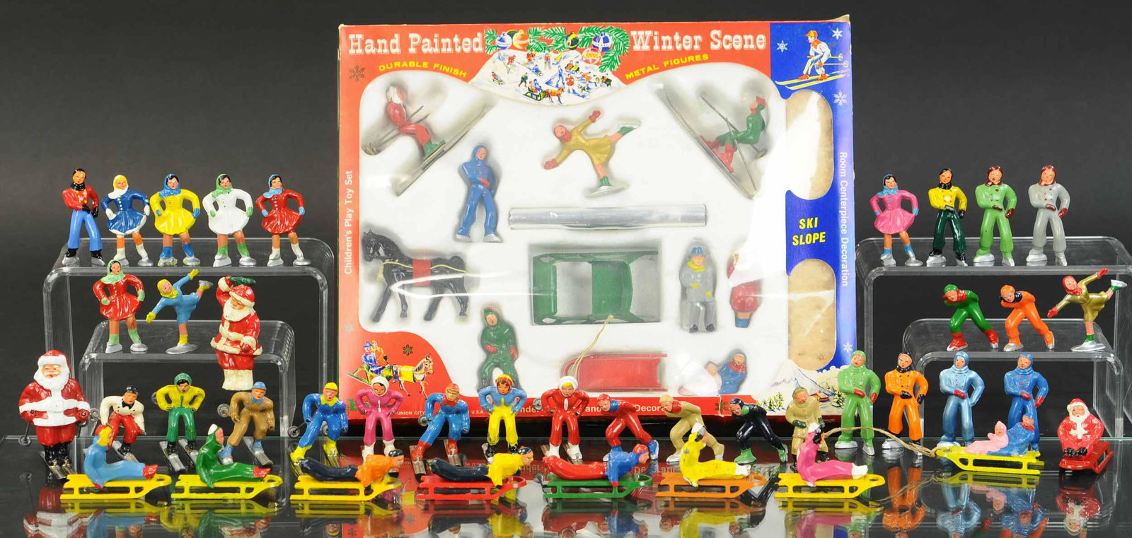 BARCLAY WINTER SPORTING FIGURES W/BOXED WINTER: 518. BARCLAY WINTER SPORTING FIGURES W/BOXED WINTER | SCENE Lot includes eight skiers, eight sledders, twenty-one skaters, three Santas and a great boxed winter scene. | 1"-2.75" high. | (Pristine Con