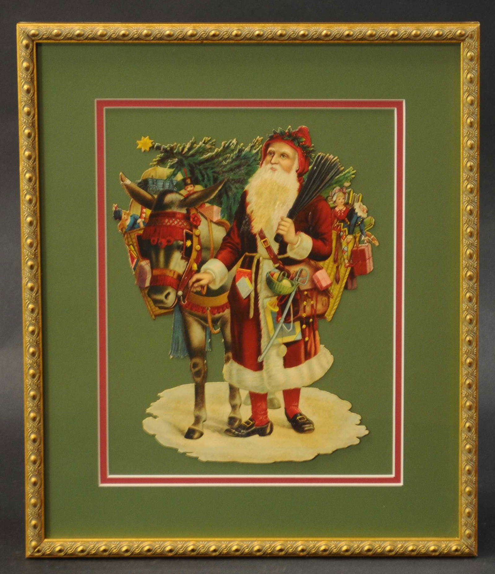 SANTA AND DONKEY DIE-CUT: 567. SANTA AND DONKEY DIE-CUT | Nicely framed, red robe Santa Claus w/basket of Christmas toys and holding a switch to punish bad children, donkey on his side, loaded w/gifts and a Christmas tree. | 1