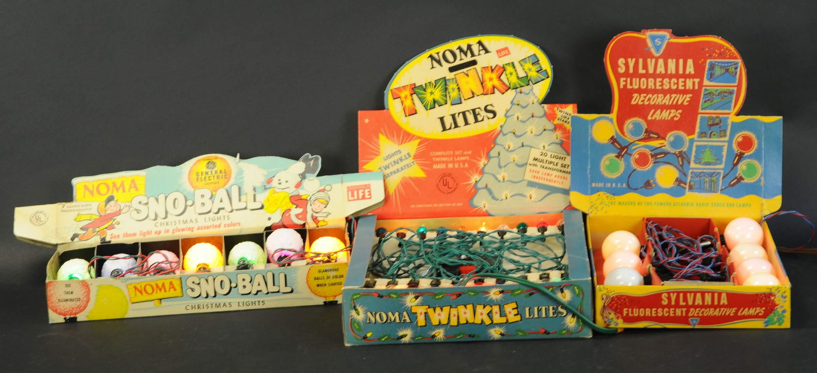 THREE BOXED CHRISTMAS LIGHT SETS: 581. THREE BOXED CHRISTMAS LIGHT SETS | Lot includes Noma SNO-BALL lights in assorted colors, Noma twinkle lights, and Sylvania FLUORESCENT decorative lamps. | Largest box 12" x 12". | (Very Good to E