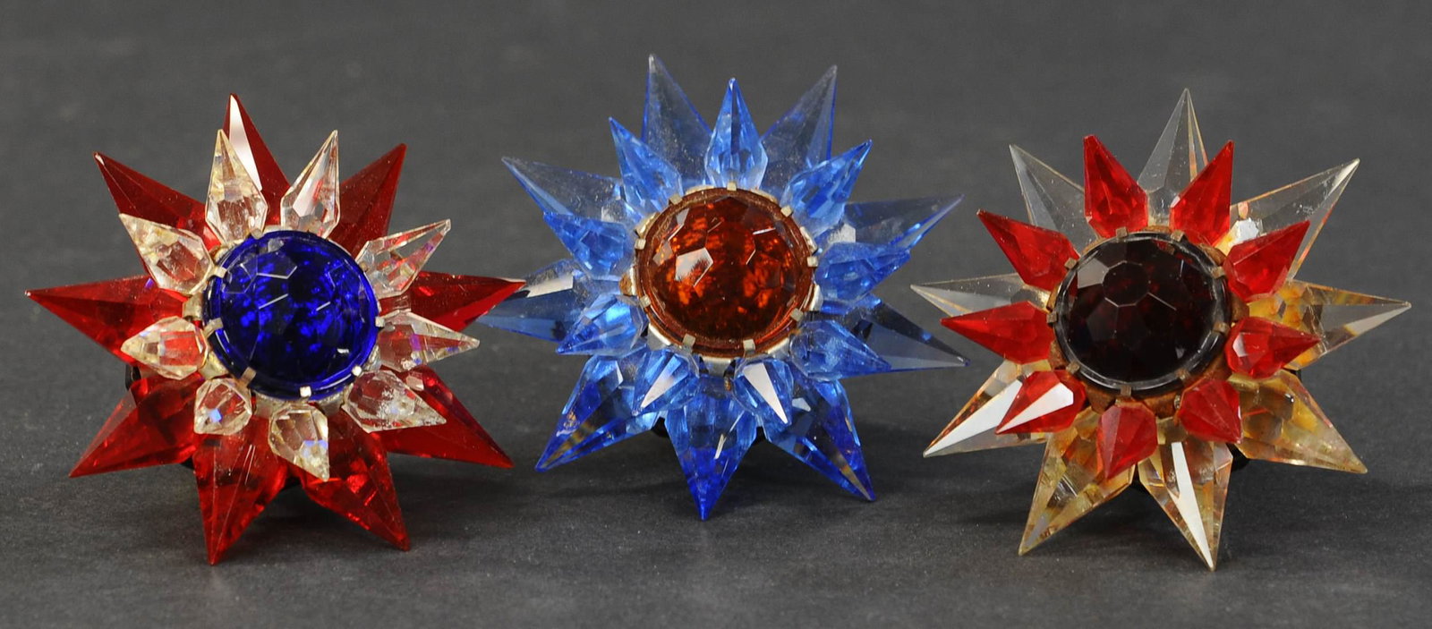 THREE 500 SERIES WONDER STARS: 595. THREE 500 SERIES WONDER STARS | Three large base Matchless Stars in three different brilliant colors, including patriotic red, white, and blue, by the Wonder Star Company. | Just over 3" diam. | 