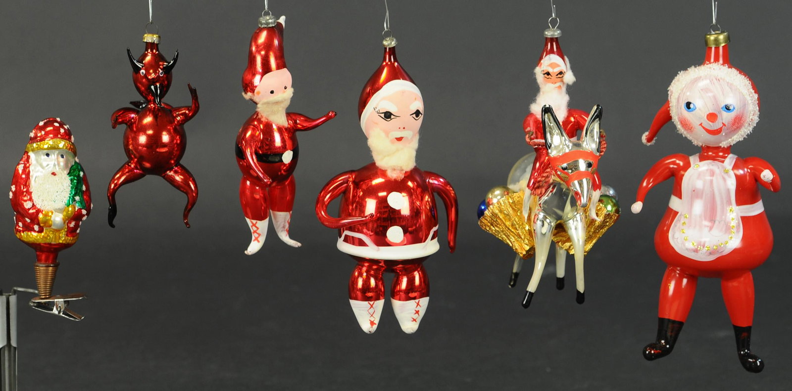 GROUP OF SIX ITALIAN GLASS SANTA ORNAMENTS: 642. GROUP OF SIX ITALIAN GLASS SANTA ORNAMENTS | Lot includes Santa on donkey, Krampus and four other Santas. | 4"-7" height. | (Excellent Condition) | $150 - $250