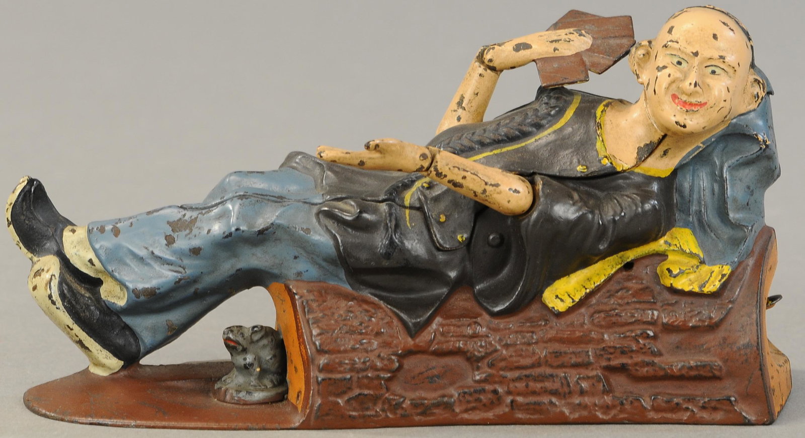 RECLINING CHINAMAN MECHANICAL BANK: 178. RECLINING CHINAMAN MECHANICAL BANK | Popular bank amongst collectors, J & E Stevens Co., circa 1885. | Hands & face appear repainted, otherwise (Exc. Cond.) | $1,500 - $2,500
