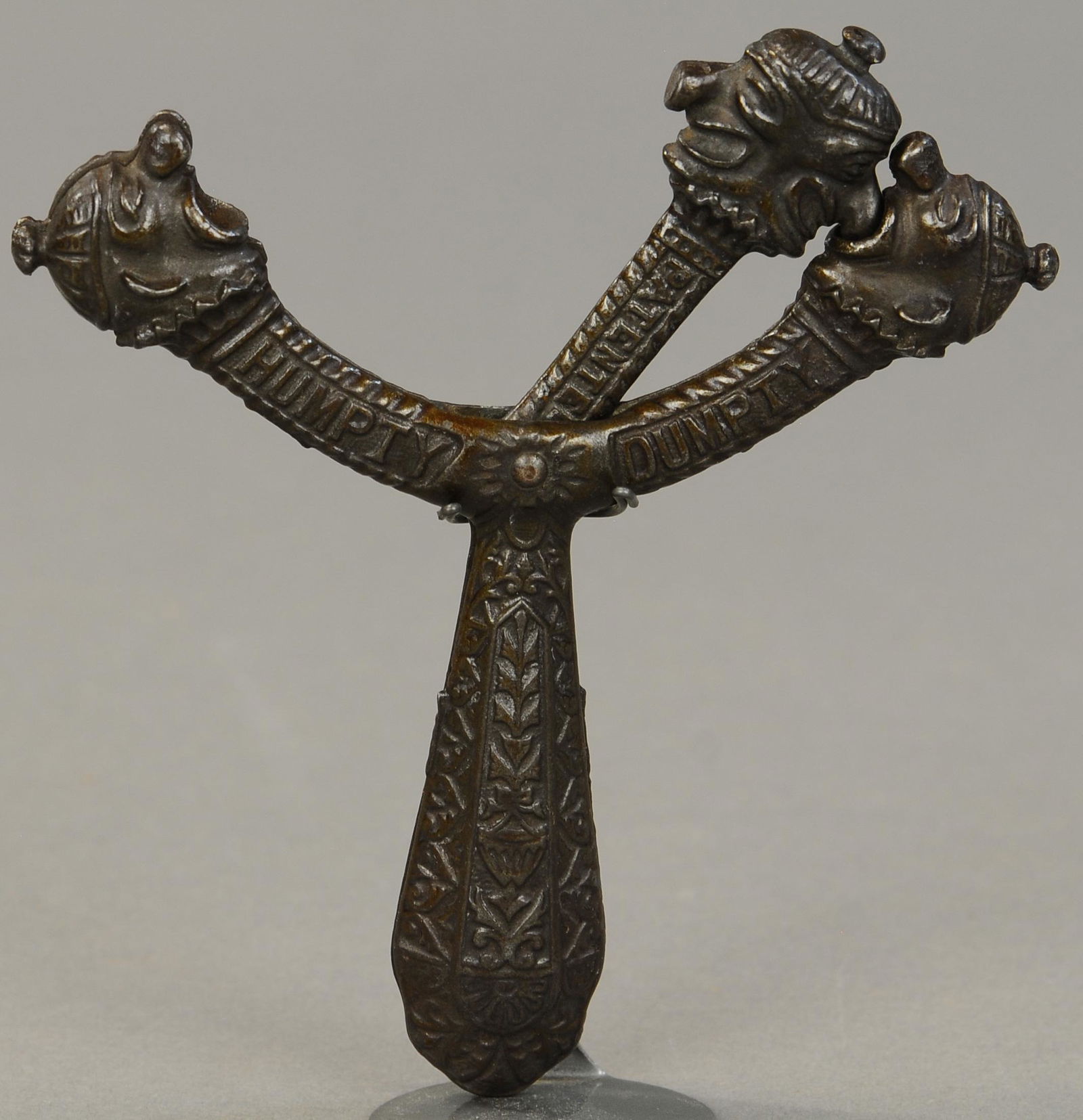 IVES DOUBLE HUMPTY DUMPTY HEAD CAP SHOOTER: 441. IVES DOUBLE HUMPTY DUMPTY HEAD CAP SHOOTER | Shaking the handle causes the clown's nose to trigger the caps, which are placed in the two outer clown's mouths. 6" l. | (VG-Exc. Cond.) | $700 - $1,