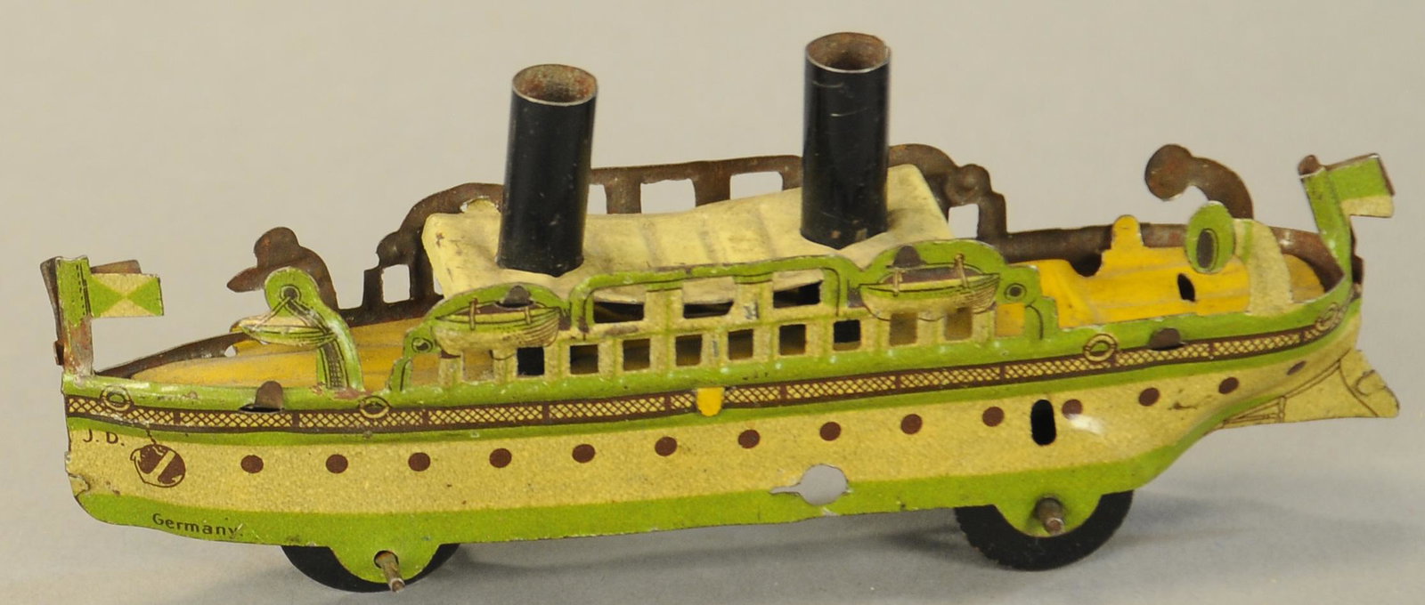 DISTLER PASSENGER BOAT PENNY TOY: 1216. DISTLER PASSENGER BOAT PENNY TOY | Unique color combination as is often seen in red and white. 5" l. | Small crack inside, otherwise in (VG Cond.) | $200 - $300