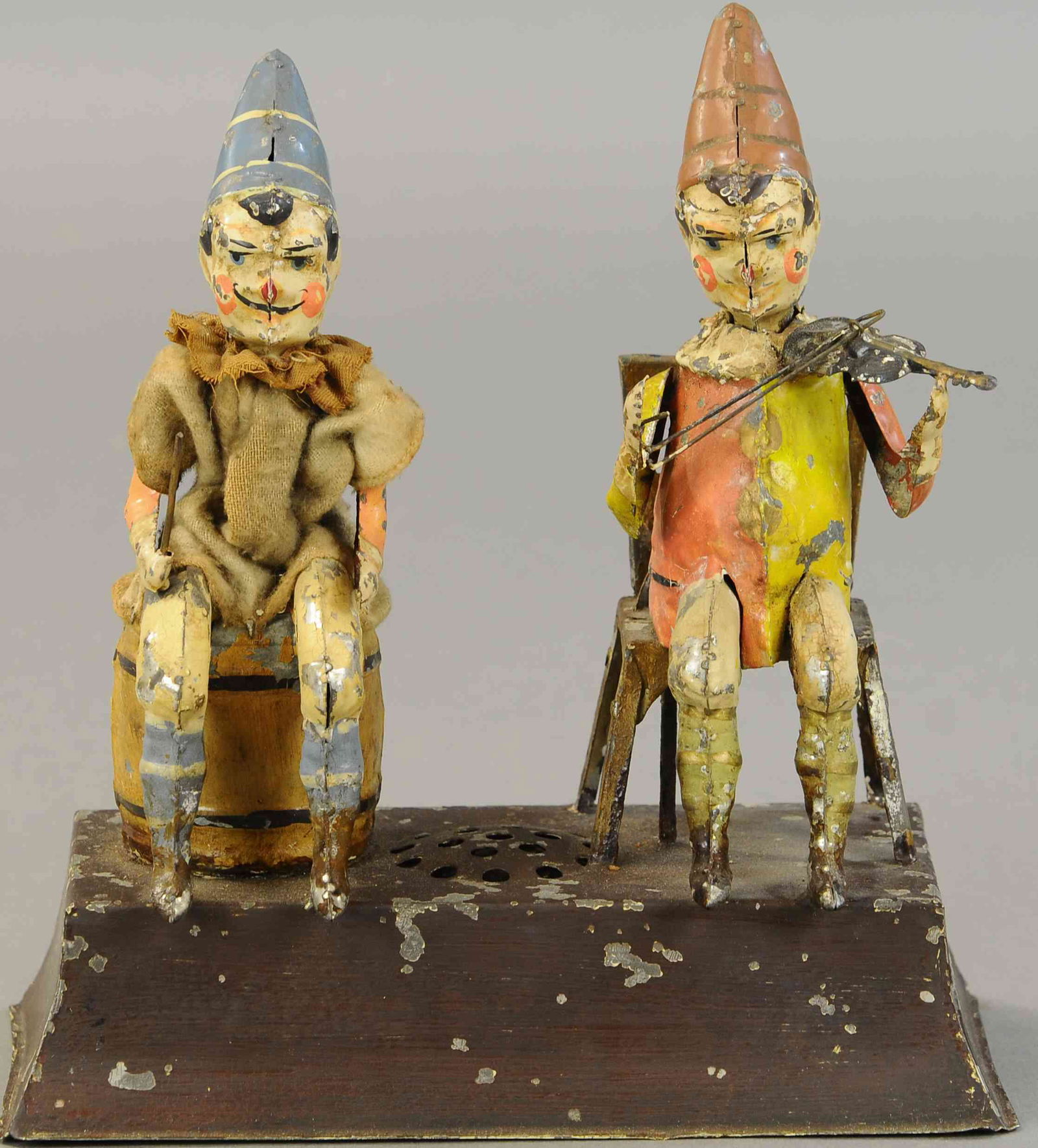 GUNTHERMANN SEATED CLOWN MUSICIANS: 1306. GUNTHERMANN SEATED CLOWN MUSICIANS | Germany, hand painted with wind-up concealed in base, nice motion and plink-plank music sound. 9 " | Base repainted, otherwise in (VG Cond.) | $1,500 - $2,00