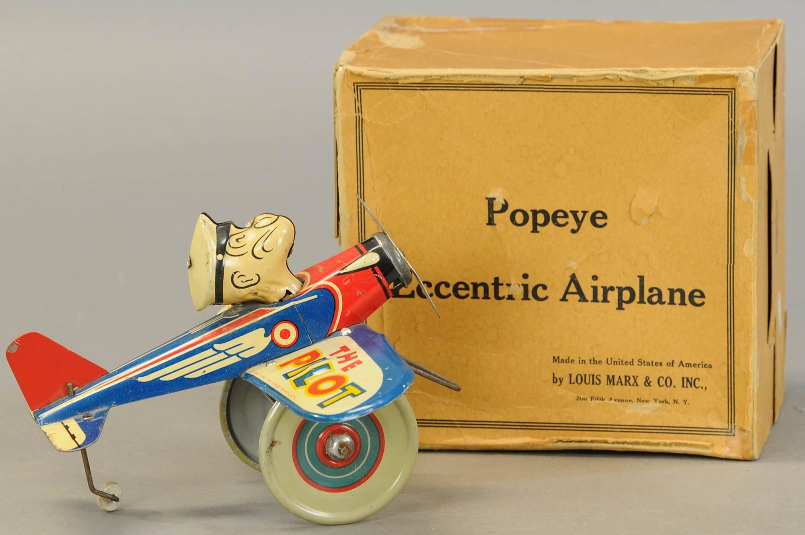 BOXED MARX POPEYE THE PILOT: 1506. BOXED MARX POPEYE THE PILOT | 8" l. | One side flap missing & repair to box, overall (Exc. Cond.) | $700 - $1,000