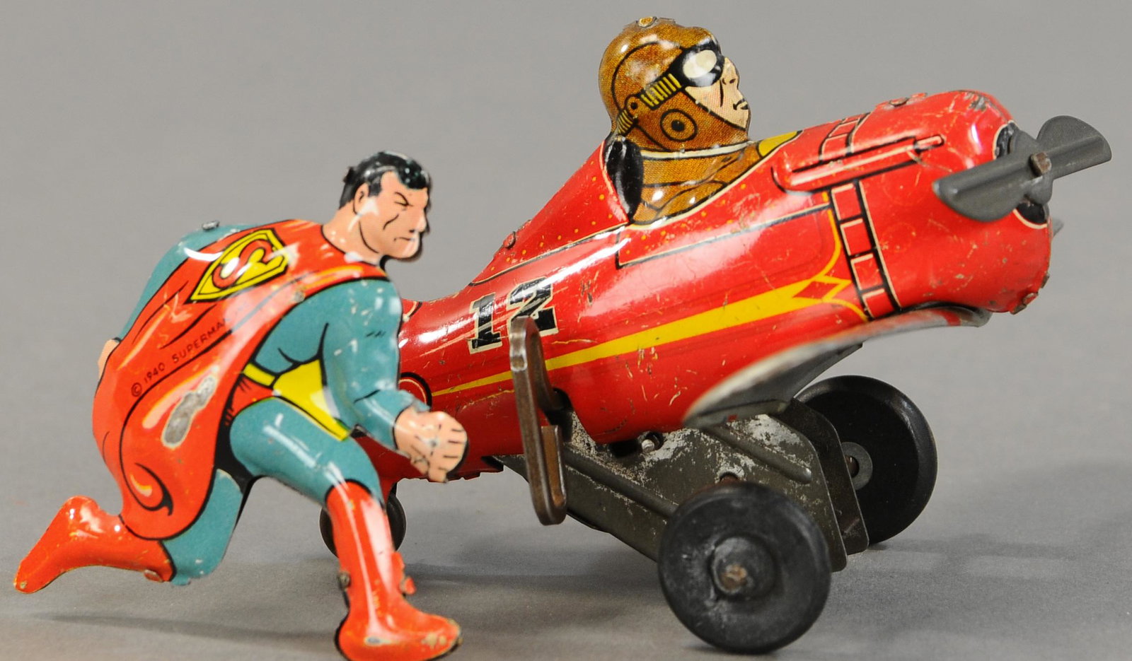 MARX SUPERMAN ROLLOVER AIRPLANE: 1520. MARX SUPERMAN ROLLOVER AIRPLANE | Desirable Superman version of an otherwise familiar Marx toy. 6" l. | Scratch on Superman's cape, otherwise (Pristine Cond.) | $700 - $1,000