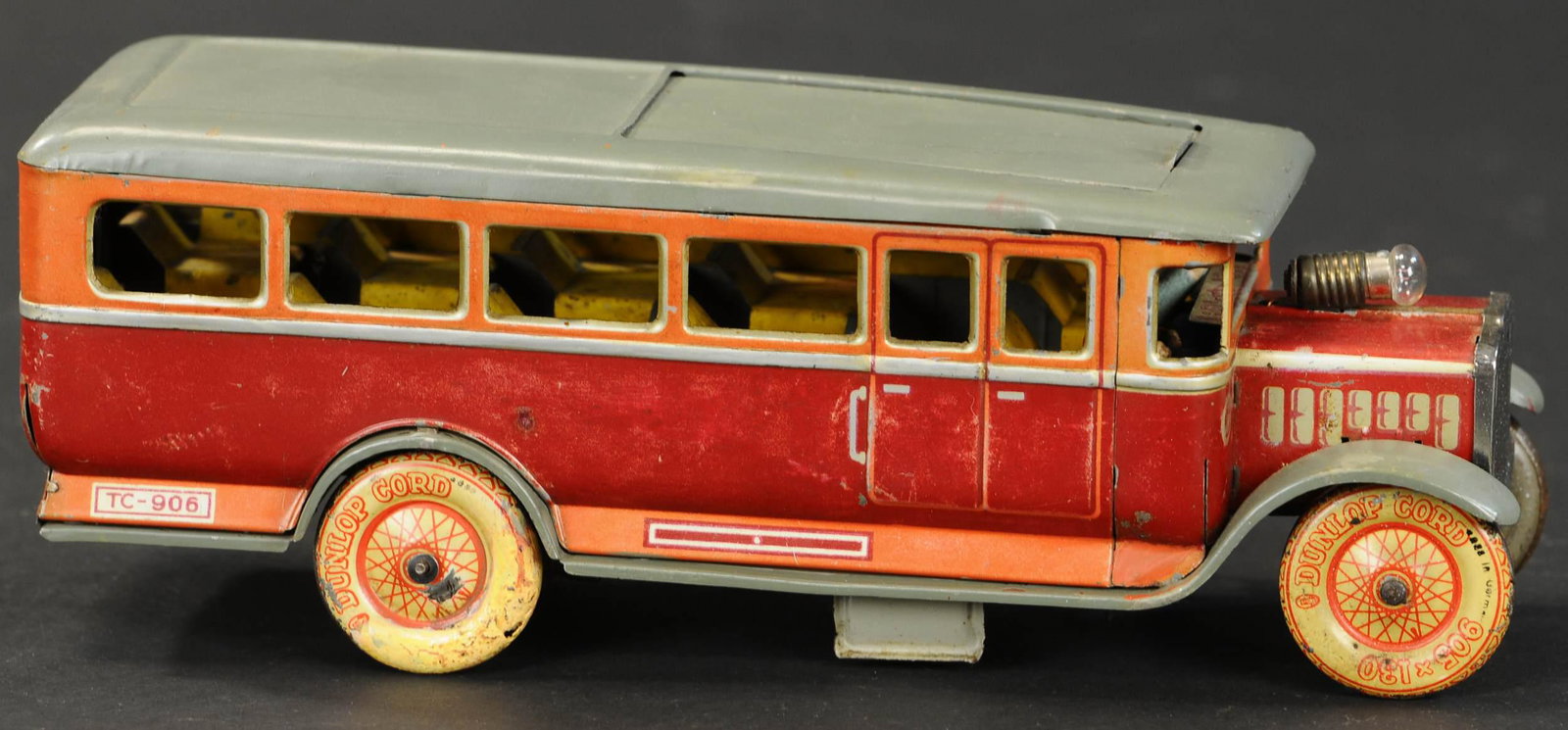 TIPPCO SLIDING ROOF BUS: 2027. TIPPCO SLIDING ROOF BUS | Hard to find example, wind-up with electric headlight at bonnet. 11" l. | Overpaint to body, one wheel and sliding section of roof appear to be replaced, (Very Good Con