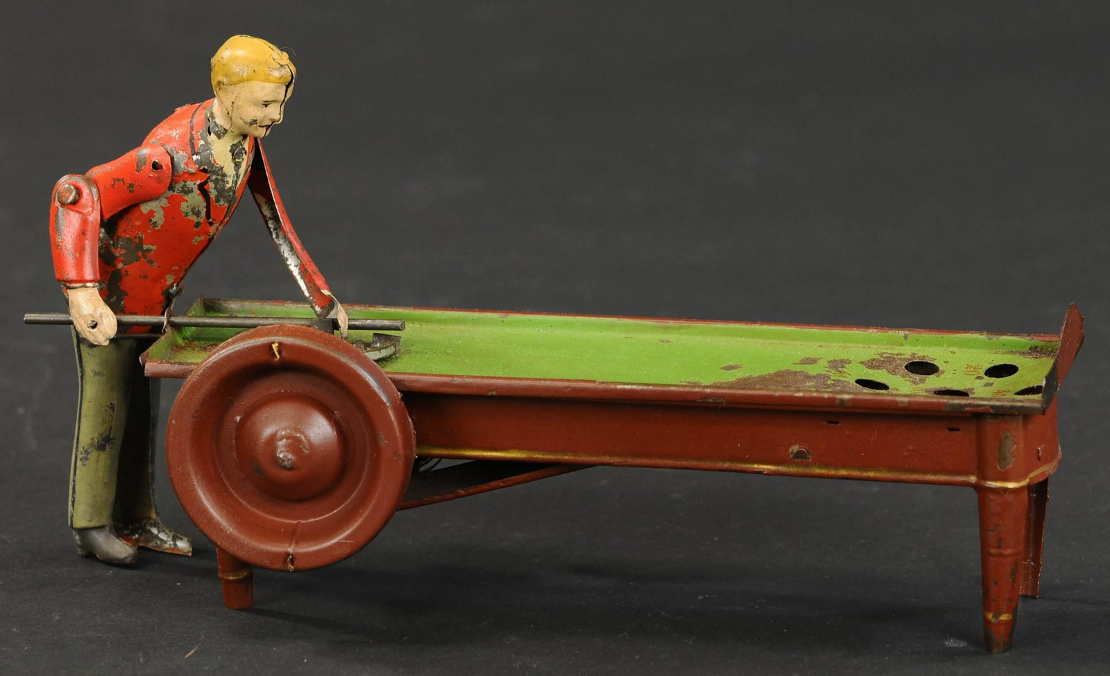 MEDIUM GERMAN TIN POOL PLAYER: 2052. MEDIUM GERMAN TIN POOL PLAYER | Interesting design with circular ball feeder. 10" l. | Overpaint to figure, otherwise in (Very Good to Excellent Condition) | $300 - $500 | Provenance: Sam Downey