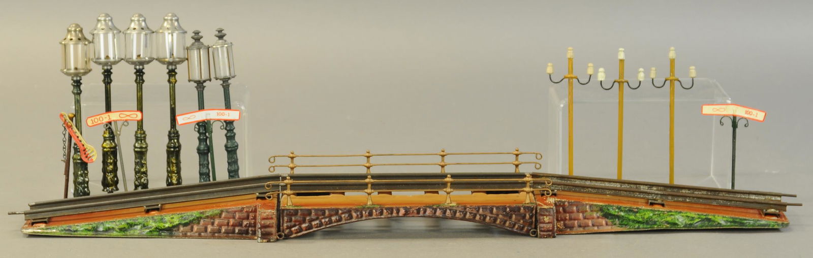 MARKLIN BRIDGE, EXTRA LAMPS & SIGNS: 2150. MARKLIN BRIDGE, EXTRA LAMPS & SIGNS | One O gauge bridge, six lamps for bridge ramps, includes three signs and three telegraph poles. 7.5" h. | Some parts are replaced, bridge in (Very Good to E