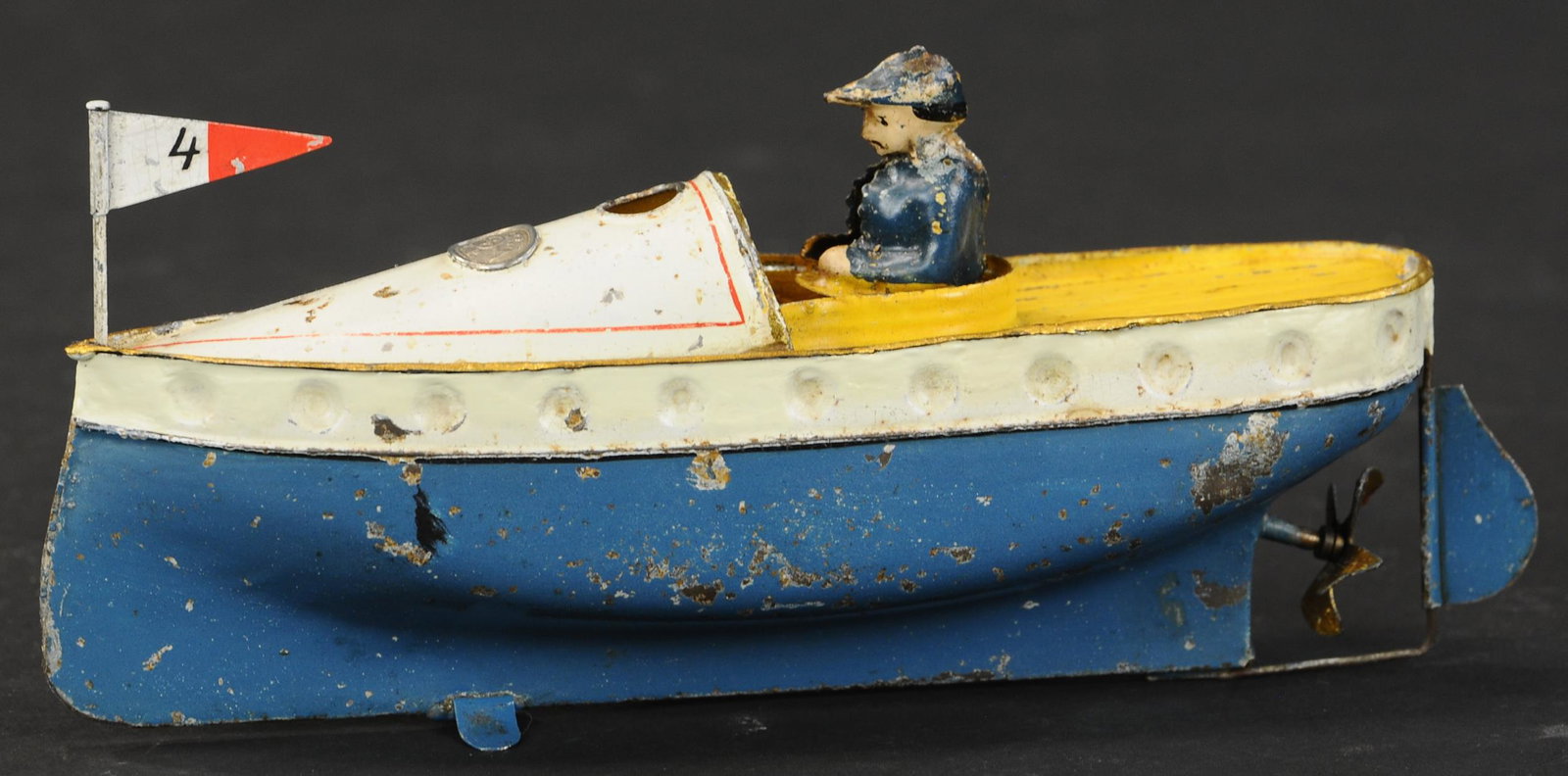 SMALL ERNST PLANK SPEED BOAT: 2178. SMALL ERNST PLANK SPEED BOAT | Wind-up bar appears behind deck windscreen, cute little speedboat design. 7.5" l. | Edge of deck resoldered & touched up, flag replaced, (Very Good to Excellent Co