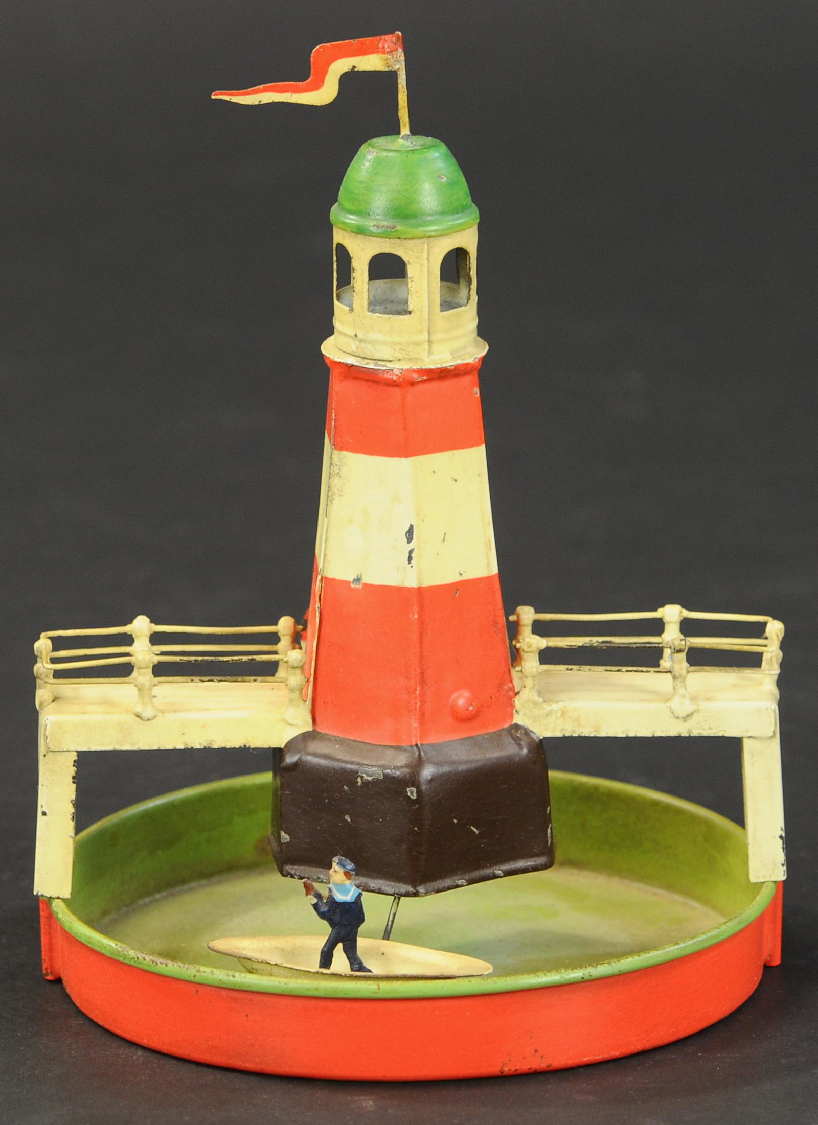 GERMAN ROWBOAT & LIGHTHOUSE TOY: 2314. GERMAN ROWBOAT & LIGHTHOUSE TOY | Small size wind-up piece. 6.5" h. | Nicely done restoration | $300 - $500 | Provenance: Sam Downey Collection.