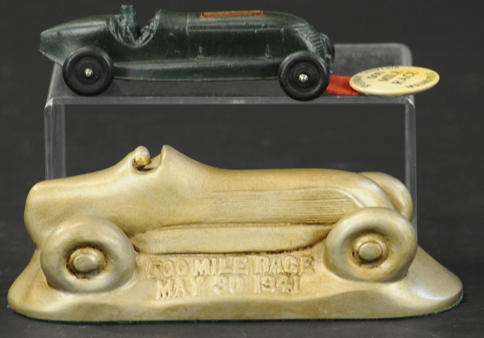 TWO 500 MILE RACE CAR SOUVENIR ITEMS: 2375. TWO 500 MILE RACE CAR SOUVENIR ITEMS | Plaster piece marked "500 Mile Race May 30, 1941," smaller green car has ribbon and pin attached. 5" - 7.5" l. | (Excellent Condition) | $200 - $400 | Prov