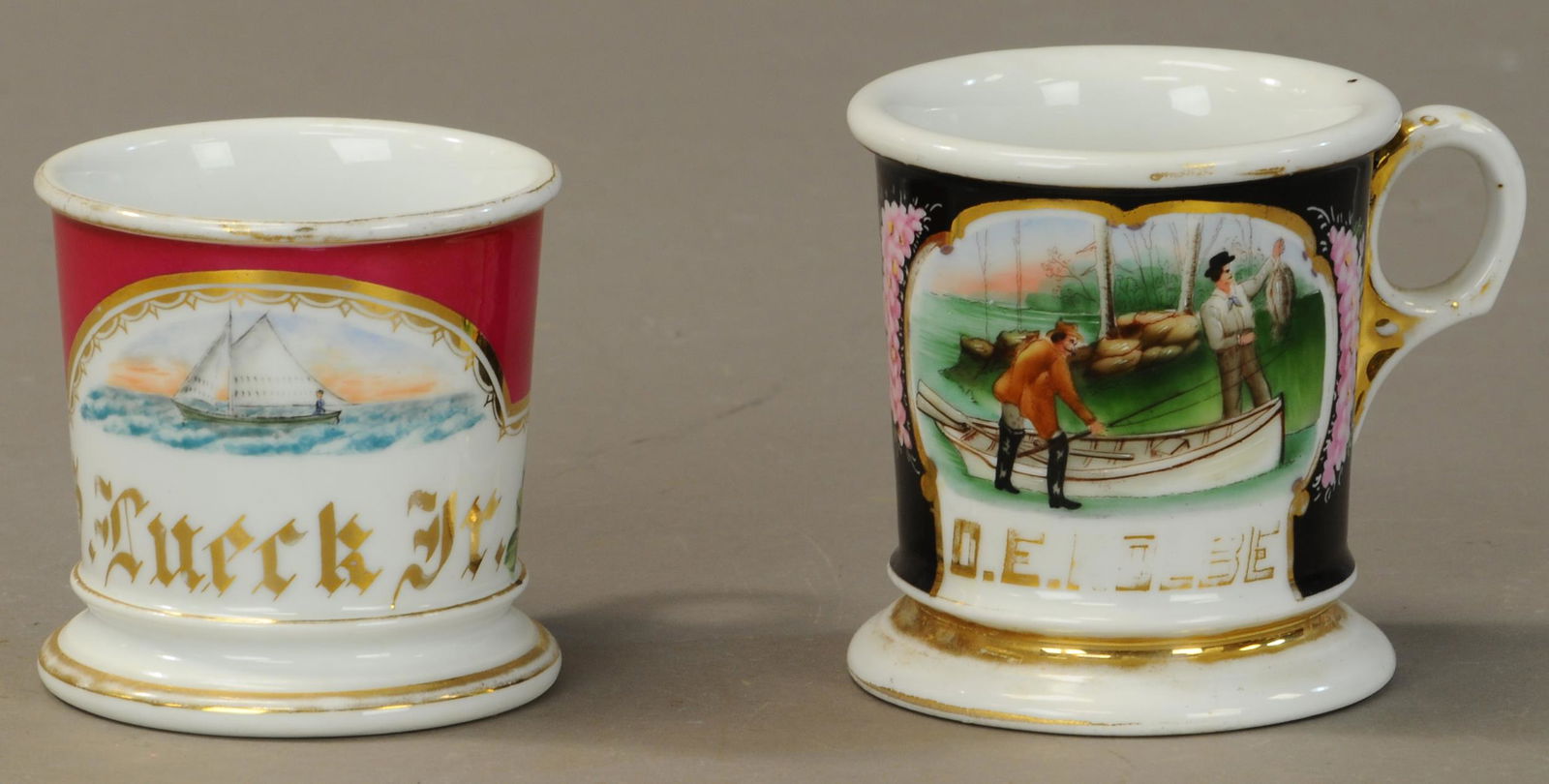 FISHING SCENE & SAILBOAT SHAVING MUGS: 2441. FISHING SCENE & SAILBOAT SHAVING MUGS | Fishing Scene - Men with boat and catch of fish. No damage 80% gold loss. Sail Boat - Small illustration red wrap gold wear to rims name full no damage. |