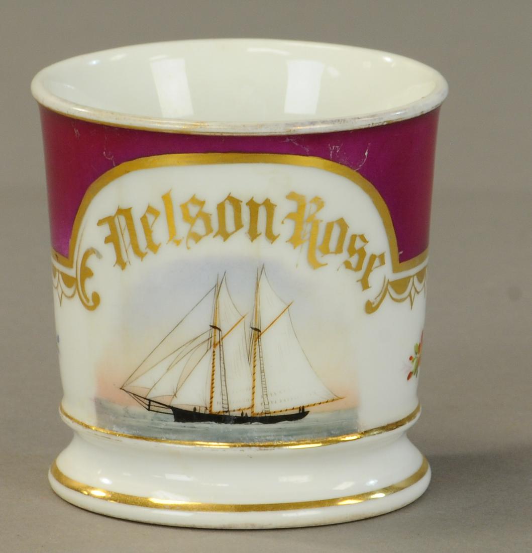 LARGE SAIL BOAT OCCUPATIONAL SHAVING MUG: 2445. LARGE SAIL BOAT OCCUPATIONAL SHAVING MUG | Red arch wrap. This is a “paint over” of another illustration by the original mug artist, not a fake. No damage gold wear to top rim, name full. -